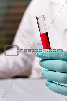 Closeup chemist with red liquid