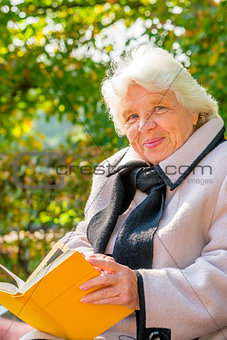 portrait of a happy grandmother on a park bench