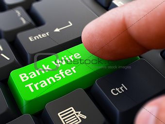 Pressing Green Button Bank Wire Transfer on Black Keyboard.