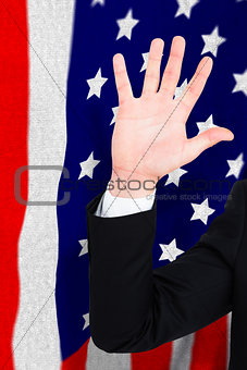 Composite image of businessman in suit with hand raised