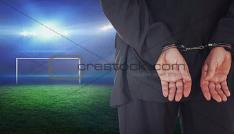 Composite image of businessman in handcuffs
