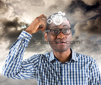 Composite image of young businessman thinking scratching head
