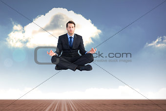 Composite image of calm businessman sitting in lotus pose