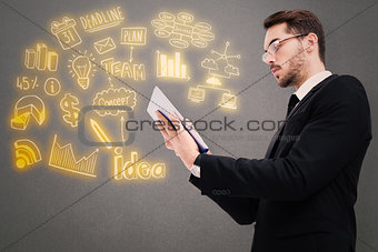 Composite image of businessman with glasses using his tablet