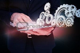 Composite image of mid section of a businessman touching digital tablet