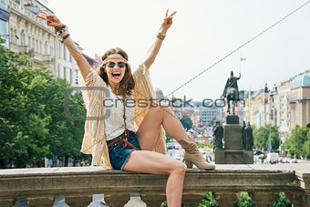 Hippie woman showing victory gesture on Wenceslas Square, Prague