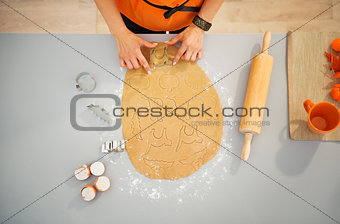 Housewife cutting out biscuits for Halloween party. Closeup
