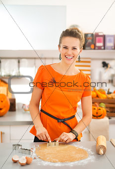 Woman cutting out Halloween biscuits in kitchen