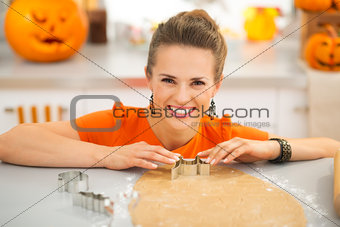 Housewife cutting out Halloween cookies in kitchen