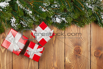 Christmas fir tree with snow and red gift boxes