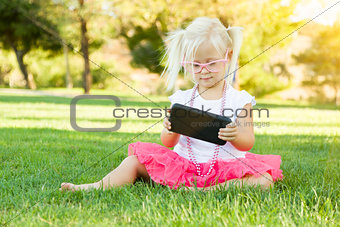 Little Girl In Grass Playing With Cell Phone