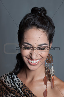 Smiling indian girl leopard spotted makeup and feathers earring