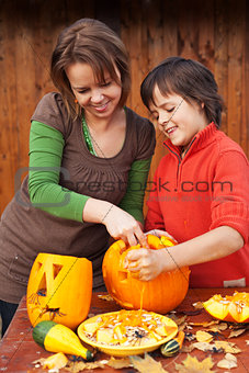 Young boy and woman carving a jack-o-lantern