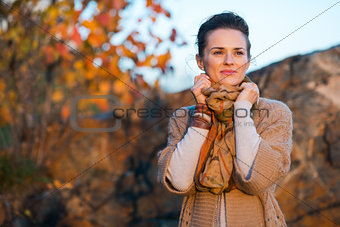 Smiling brown-haired woman relaxing in autumn park