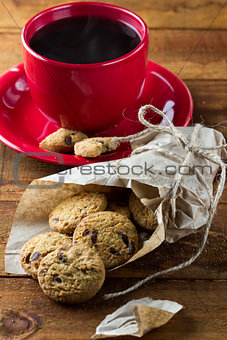 cup of coffee and oatmeal cookies with chocolate. vertical