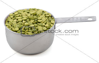 Green split peas in a measuring cup