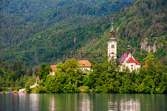 Island with Catholic Church on Bled Lake in Slovenia. Hill with Forest in Background.