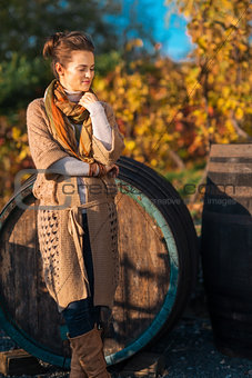 Portrait of relaxed woman winemaker standing in autumn vineyard
