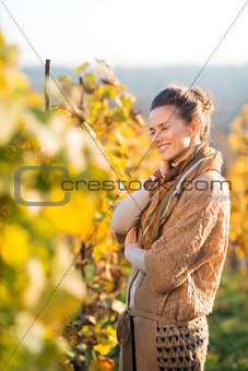 Relaxed woman winegrower standing in vineyard outdoors in autumn