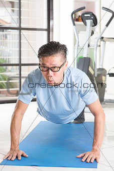 Mature Asian man pushup at gym