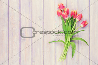 Red tulips over purple wooden table