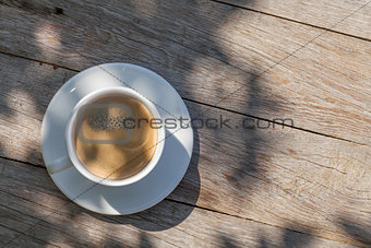 Coffee cup on sunny garden table