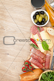 Red wine with cheese, olives, tomatoes, prosciutto, bread and sp