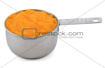 Pureed pumpkin in a measuring cup