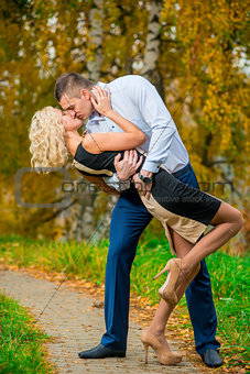 young couple passionately kissing in autumn park