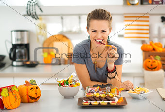Smiling woman eating trick or treat halloween candy