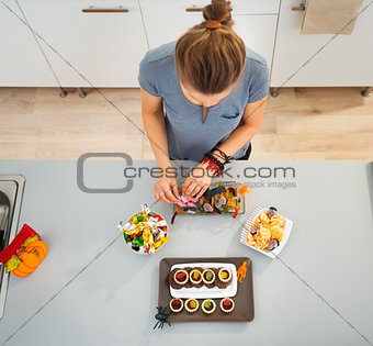 Woman preparing horribly tasty treats for halloween party