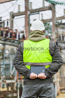 Electrical Engineer with tablet PC in electrical substation