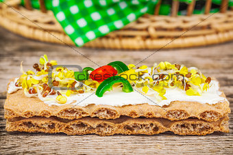 Whole grain crisp bread with sprouts on wooden table