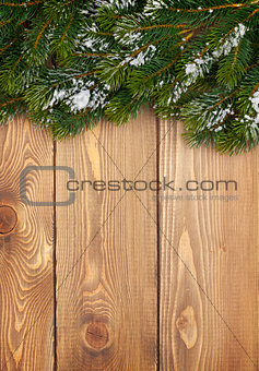 Christmas fir tree with snow on rustic wooden boardc