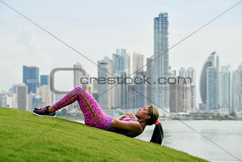 Woman Training ABS And Working Out In City Park