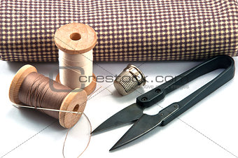 Thimble, needle, spools and scissor with cloth for hand sewing work