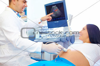 doctor conducting the ultrasound diagnostic to pregnant woman