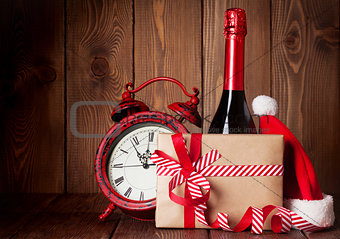 Christmas gift, alarm clock, santa hat and champagne