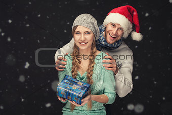 Happy Couple in Santa's Hat with New Year Gift