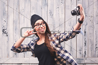 Hipster girl in glasses making selfie