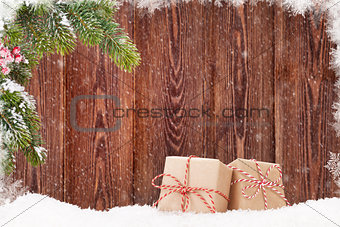 Christmas gift boxes and fir tree branch in snow