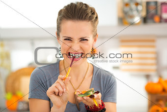 Young woman eating halloween gummy worm candies