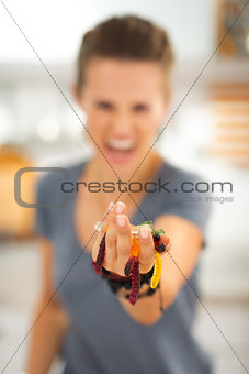 Closeup on colorful halloween gummy worm candies in woman hands