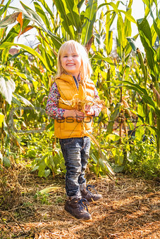 Portrait of cute smiling child in the corn field on farm