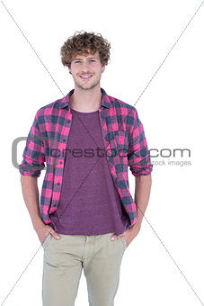Happy handsome man looking at camera with hands in pockets