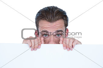 Man hiding by blank paper