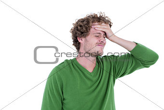Anxious casual man standing with hand on forehead