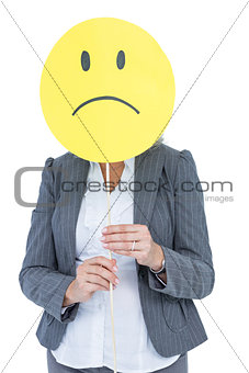 Businesswoman holding sad smiley face
