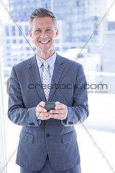 Businessman texting with his smartphone