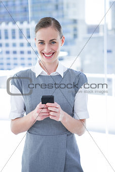 Smiling businessman texting with his mobile phowomen